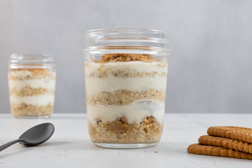 Vegane Overnight Oats Japanese Cheesecake im Glas mit deutlich sichtbaren cremigen Schichten und Löffel