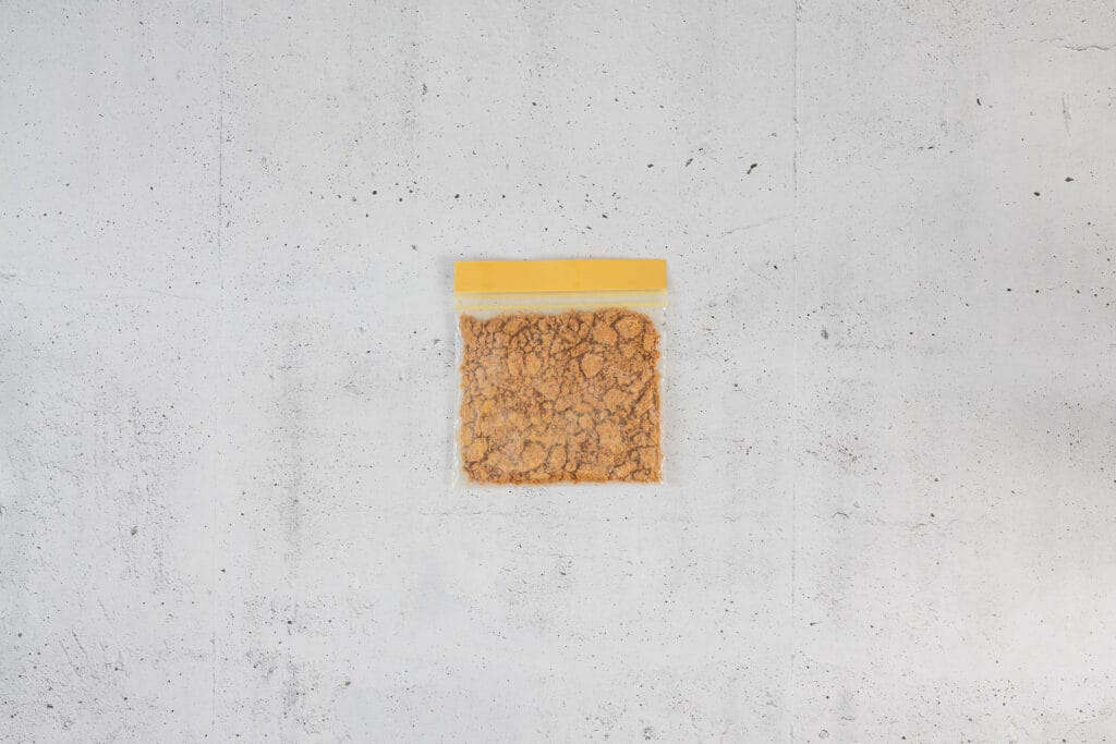 Lotus Biscoff Biscuits in einem Beutel fein zerbröselt für vegane Overnight Oats im Japanese-Cheesecake-Stil