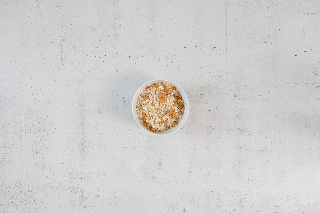 Vermischte Hafer-Biscoff-Mischung in einer Schüssel als Basis für vegane Japanese Cheesecake Overnight Oats