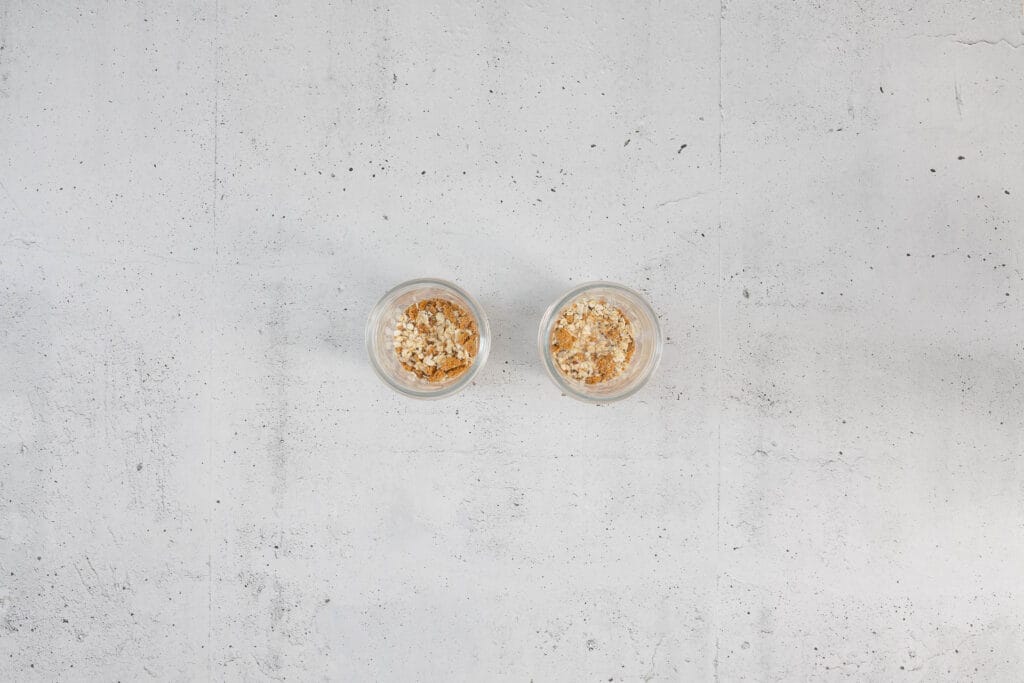 Hafer-Biscoff-Mischung mit pflanzlicher Milch in zwei Gläsern als zweiter Schritt der Zubereitung