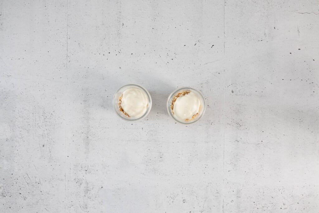 Zweite Schicht pflanzliches Joghurt über der Hafermischung für vegane Overnight Oats Japanese Cheesecake