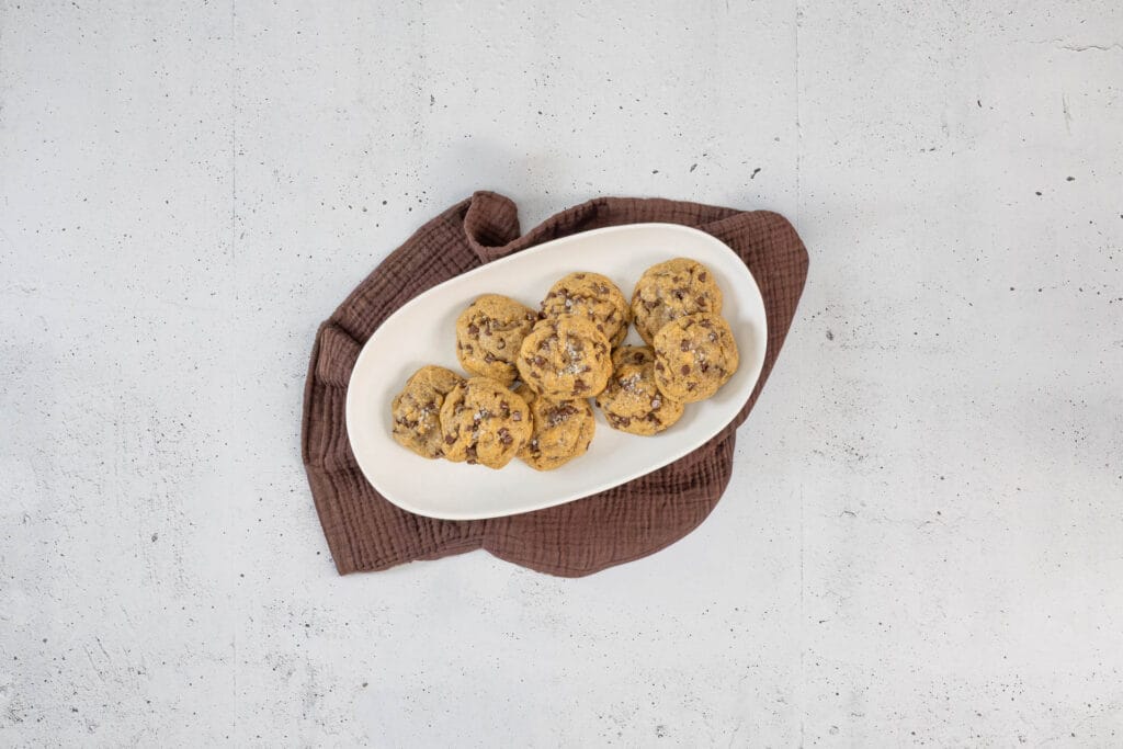 Vegane Chocolate Chip Cookies mit Meersalz auf einer Servierplatte – aussen knusprig, innen chewy nach amerikanischem Rezept