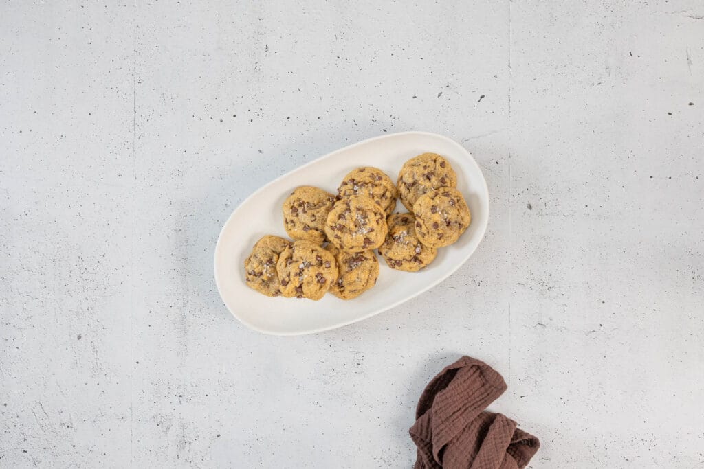 Vegane Chocolate Chip Cookies mit Schokodrops und Meersalz auf einer Platte – chewy und saftig nach amerikanischem Original