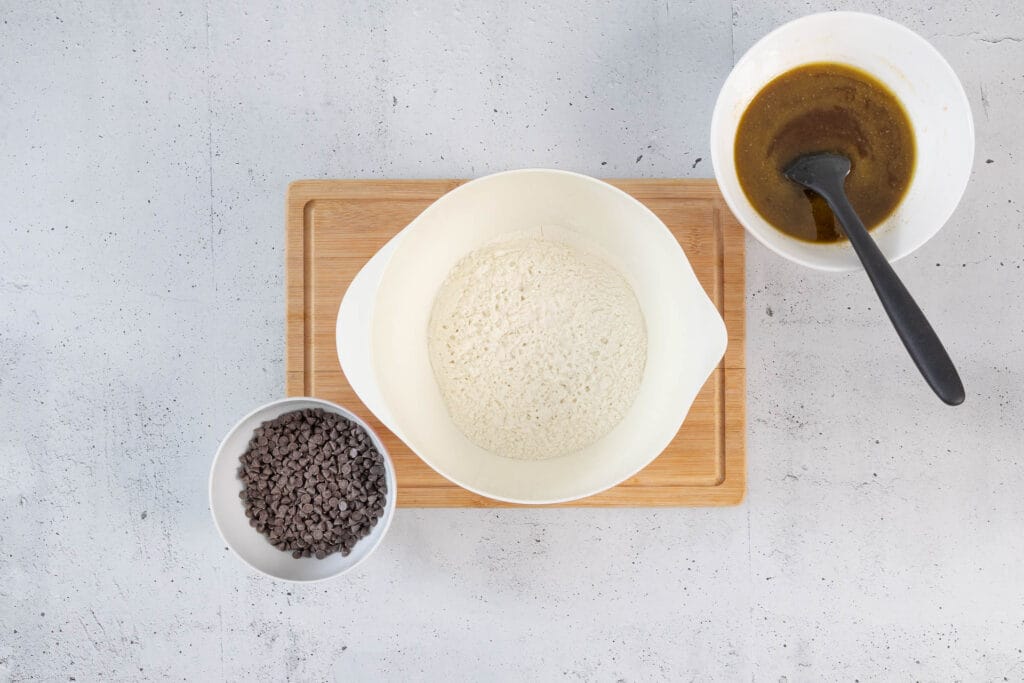 Trockene und nasse Zutaten bereit zum Vermengen – mit Schokodrops und Brown-Sugar-Butter-Mischung für chewy Cookies