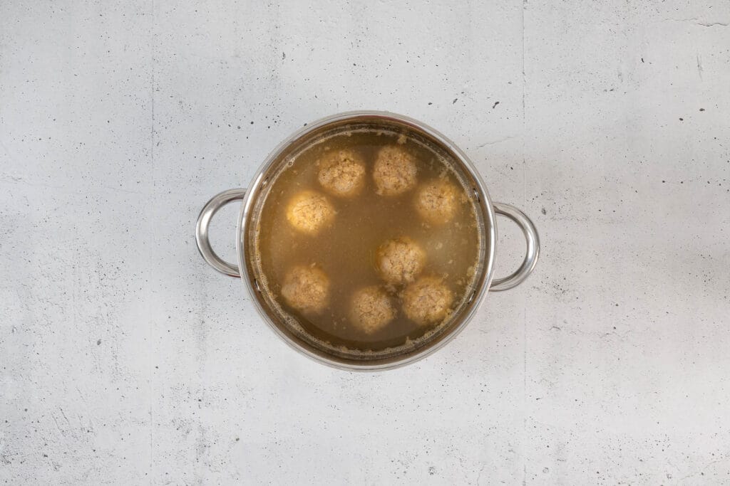 Vegane Königsberger Klopse ziehen unter dem Siedepunkt in der aromatischen Klopsbrühe