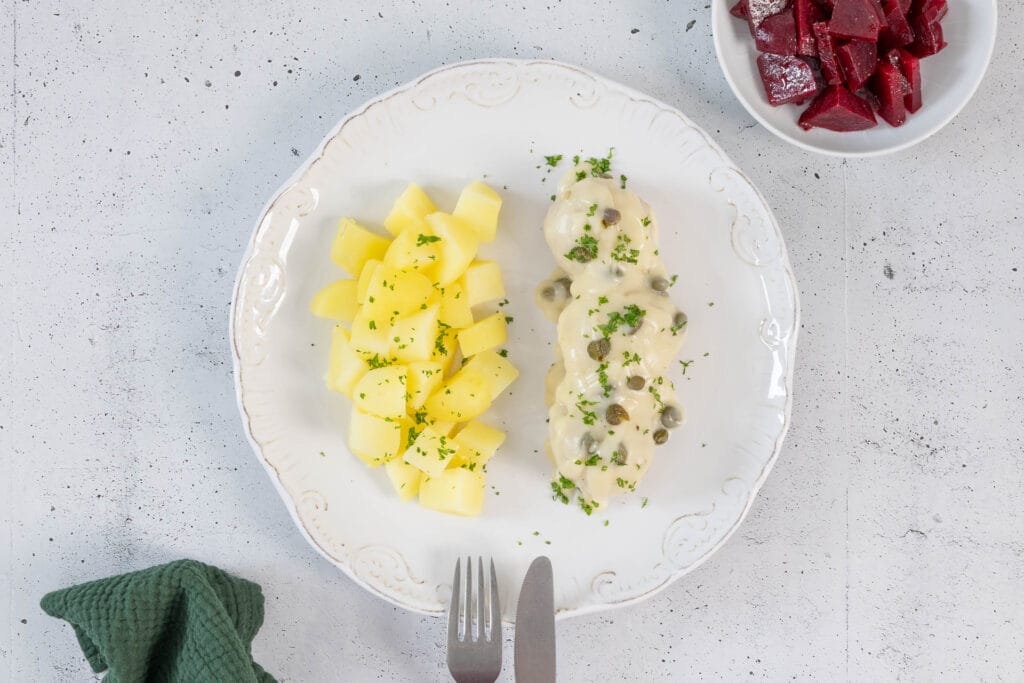 Vegane Königsberger Klopse in Kapernsauce mit Petersilie, serviert mit Salzkartoffeln und Rote Bete
