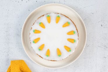 Klassische vegane Rüeblitorte von oben mit weisser Glasur und Marzipandekor