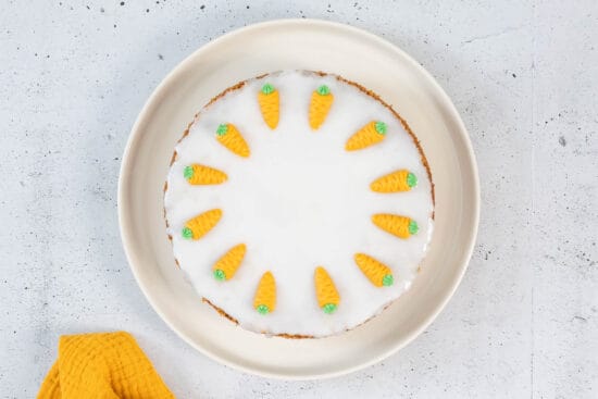 Klassische vegane Rüeblitorte von oben mit weisser Glasur und Marzipandekor