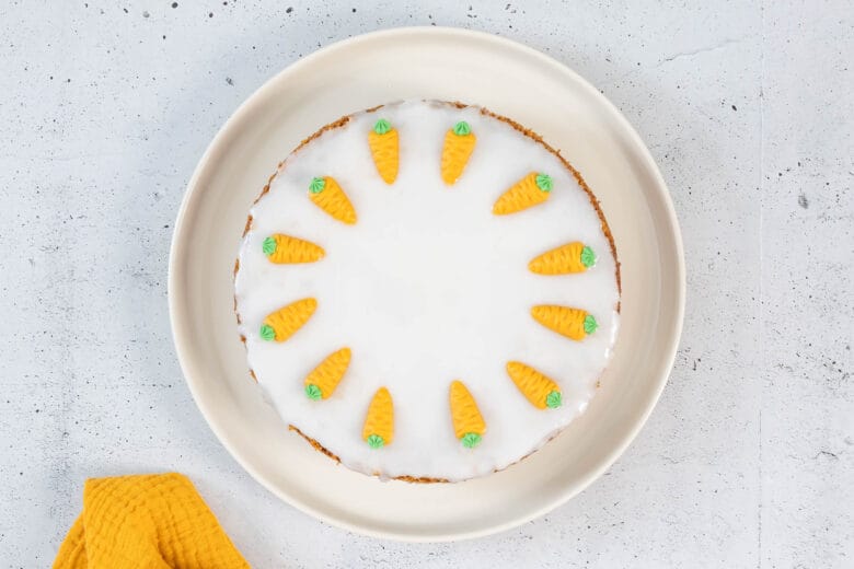 Klassische vegane Rüeblitorte von oben mit weisser Glasur und Marzipandekor