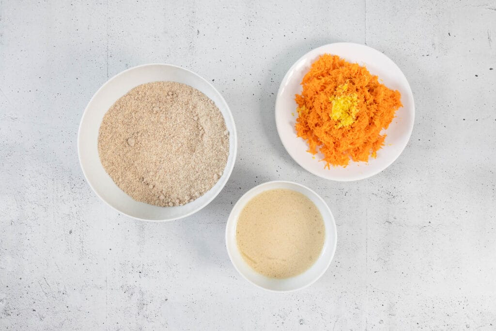 Vorbereitung für veganen Karottenkuchen mit trockenen Zutaten, Karotten mit Zitrone und flüssiger Mischung