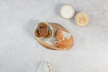 Schale mit knusprigen Falafel, Fladenbrot und zwei Dips – Hummus und Joghurt zum Falafel servieren