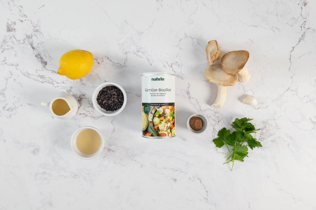 Zutaten für vegane Muschelpasta auf Marmor: Kräuterseitlinge, Knoblauch, Zitrone, Petersilie, Nori, Miso und Nahrin-Bouillon