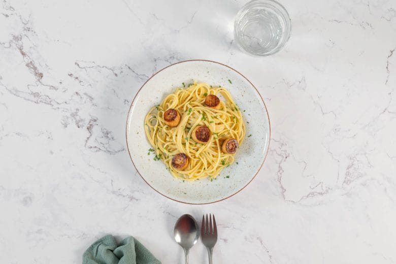 Linguine mit Pilz-Muscheln in Weissweinsauce von oben fotografiert, fein gehackte Petersilie als Garnitur