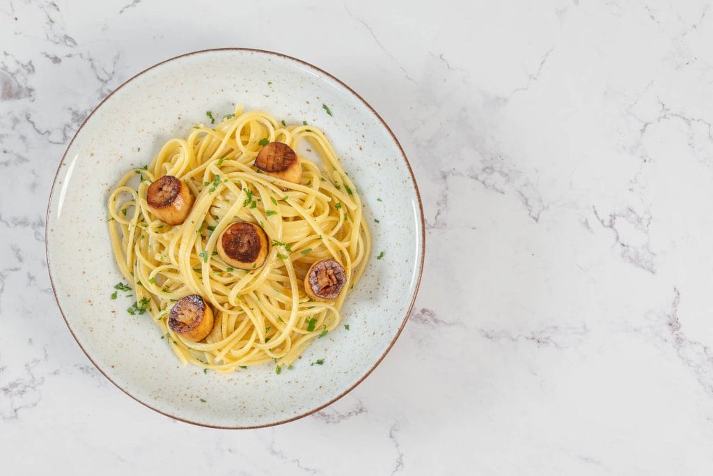 Nahaufnahme der Linguine mit Pilz-Muscheln in Weisswein-Knoblauch-Sauce, garniert mit frischer Petersilie