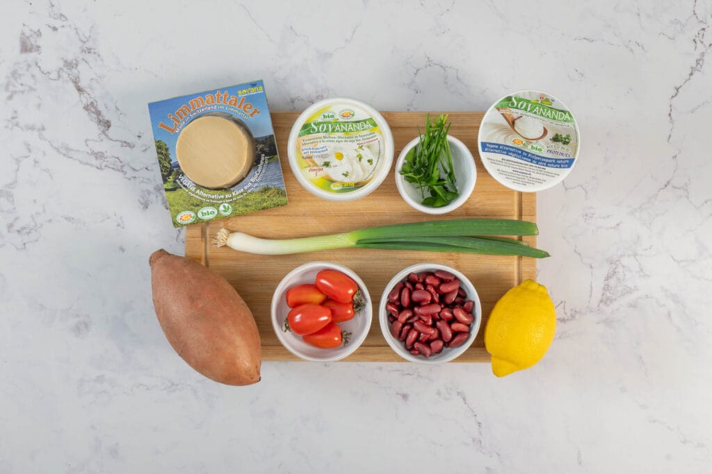 Zutaten für gefüllte Süsskartoffeln vegan: Süsskartoffel, Kidneybohnen, Cherrytomaten, veganer Käse, Quark und Sauerrahm von Soyana sowie Zitrone und Kräuter