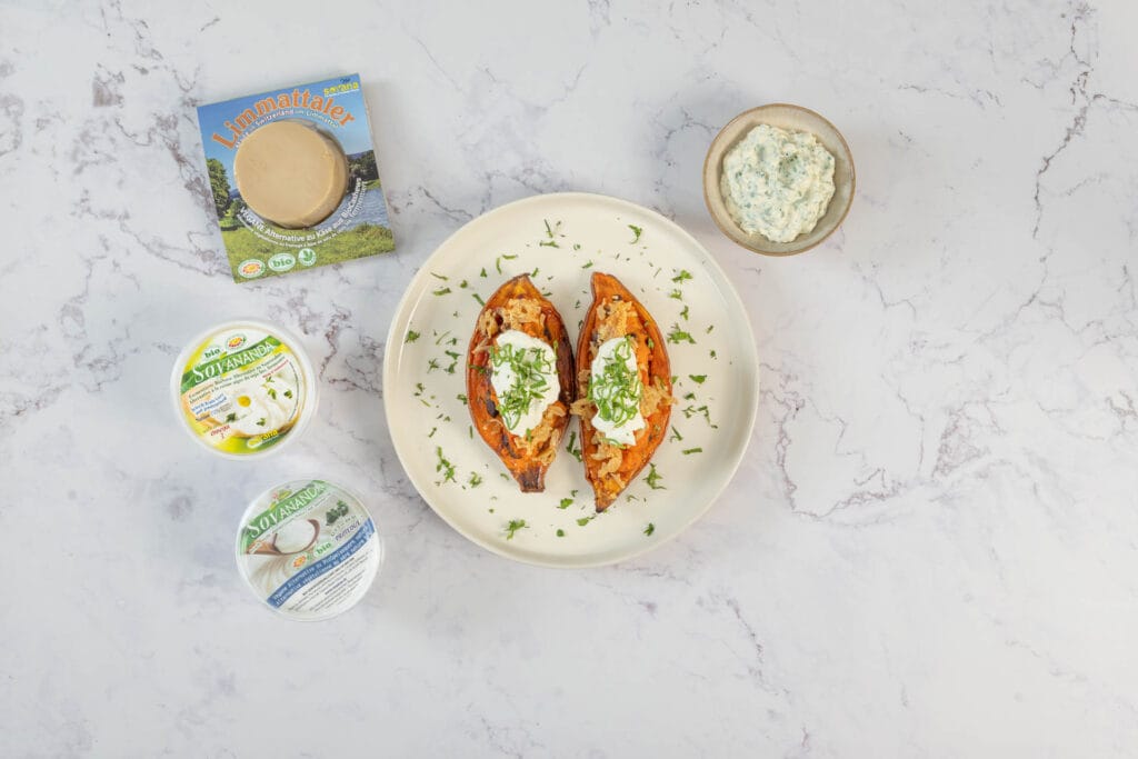 Fertige gefüllte Süsskartoffeln vegan mit Sauerrahm und Kräuterdip, daneben die Soyana-Produkte