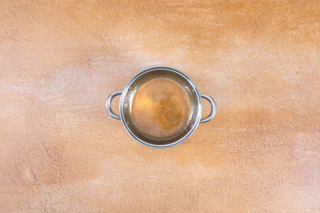 Balsamico Bianco und Zucker werden in einer kleinen Pfanne für das Agrodolce aufgekocht