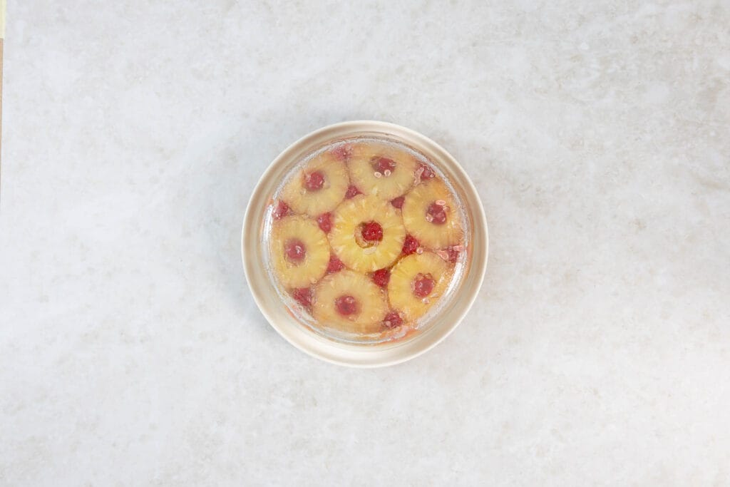 Veganer Ananas Upside Down Cake frisch auf die Tortenplatte gestürzt, die Form noch darüber