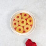 Fertiger veganer Ananaskuchen mittig auf rundem Teller, daneben eine zusammengelegte rote Serviette