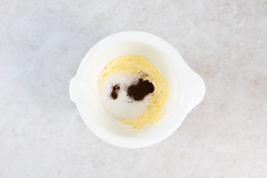 Zucker und Vanillepulver werden zur aufgeschlagenen veganen Butter gegeben