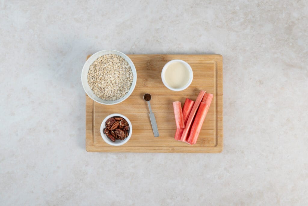 Zutaten für veganes Porridge mit Rhabarberkompott: Haferflocken, Sojamilch, Pekannüsse, Vanille und frischer Rhabarber