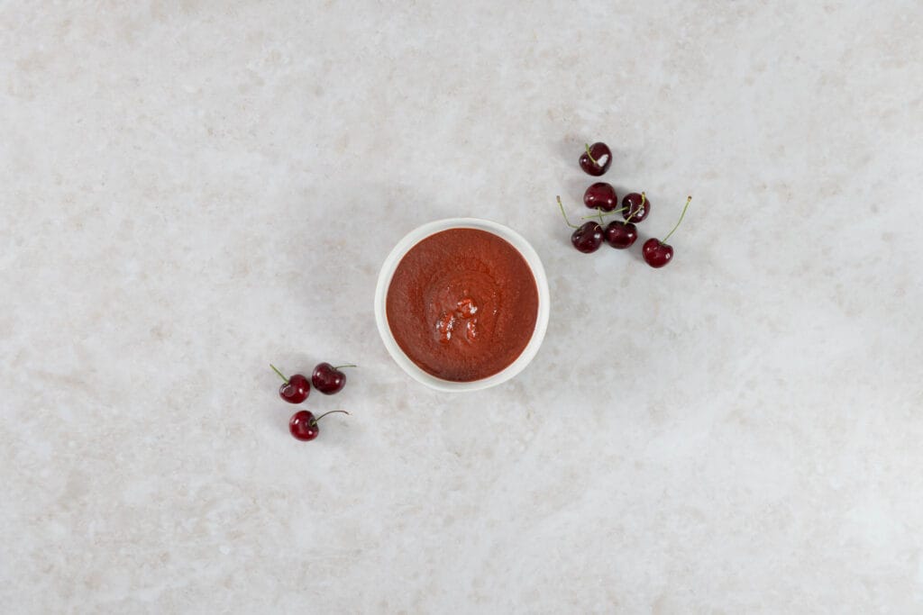 Fertige Kirsch-BBQ-Sauce im Schälchen mit frischen Zuger Chriesi