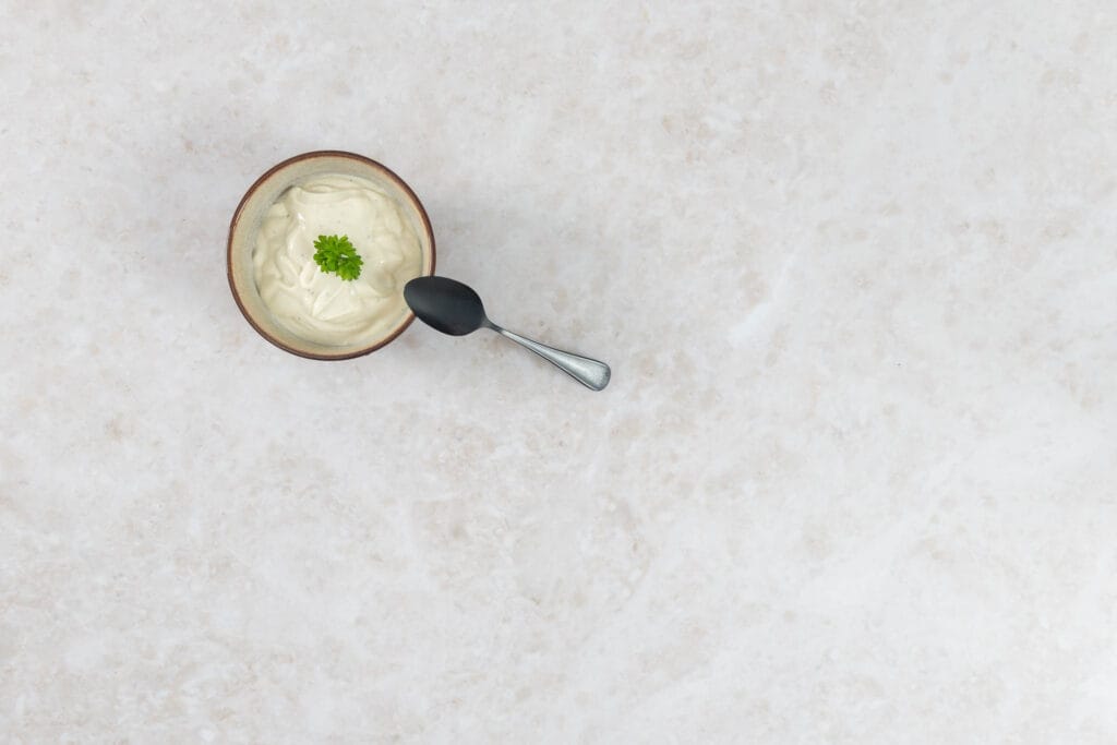 Kalorienarme Seidentofu-Mayonnaise im Schälchen mit Löffel, bereit zum Servieren