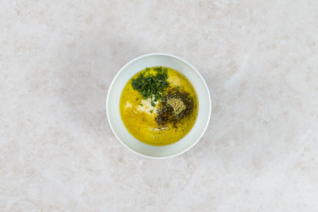Zutaten für das cremige Joghurt-Dressing mit frischen Kräutern und Salat-Mix in einer Schale