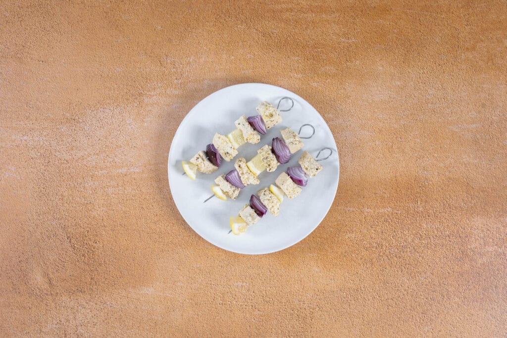 Rohe Tofu Souvlaki Spiesse mit Tofu, roter Zwiebel und Zitrone, bereit zum Grillieren