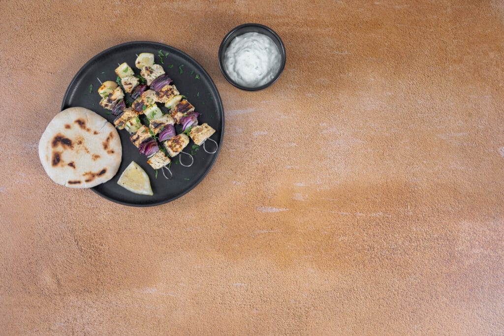 Vegane Souvlaki vom Grill mit goldbraunem Tofu, dazu Pitabrot und veganes Tzatziki