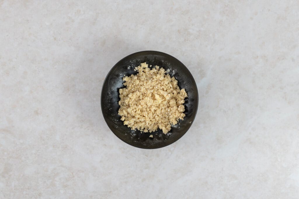 Grobe Haferflocken-Streusel mit kalter veganer Butter zu Krümeln verrieben