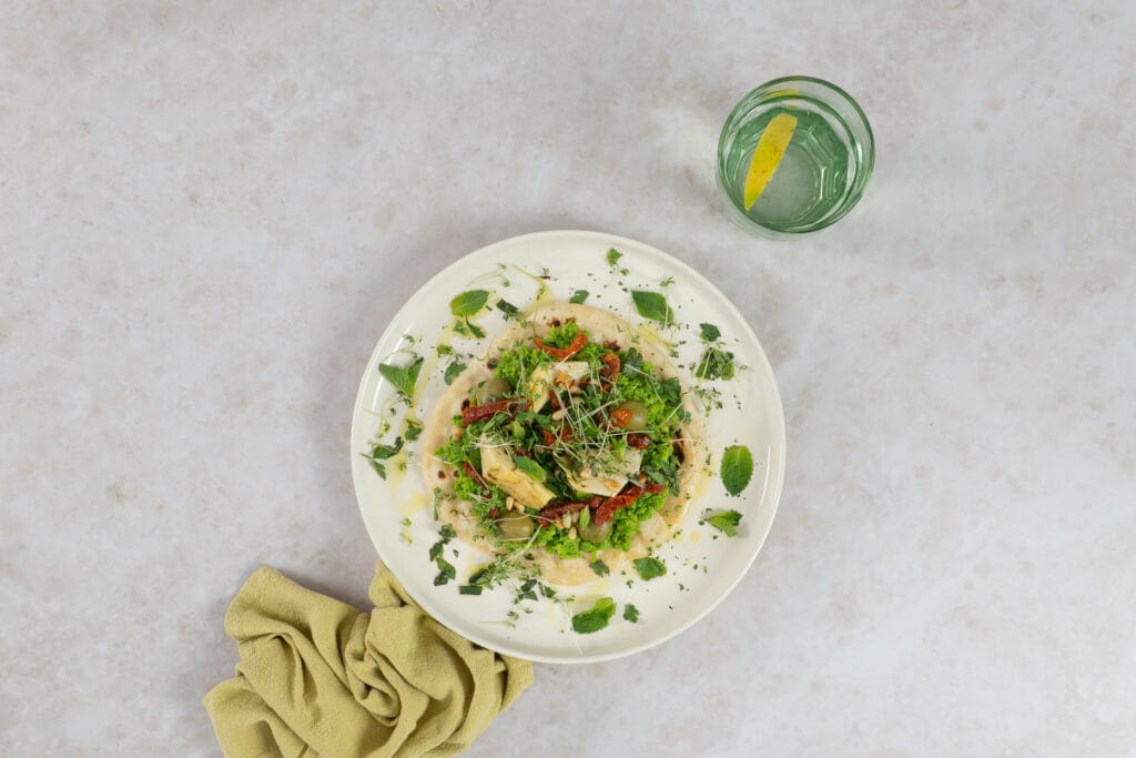 Fladenbrot mit Erbsencreme, Pinienkernen und Gartenkresse als vegane Vorspeise