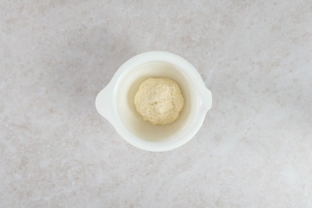 Fertig gekneteter Fladenbrotteig mit veganem Joghurt als Teigkugel in der Schüssel