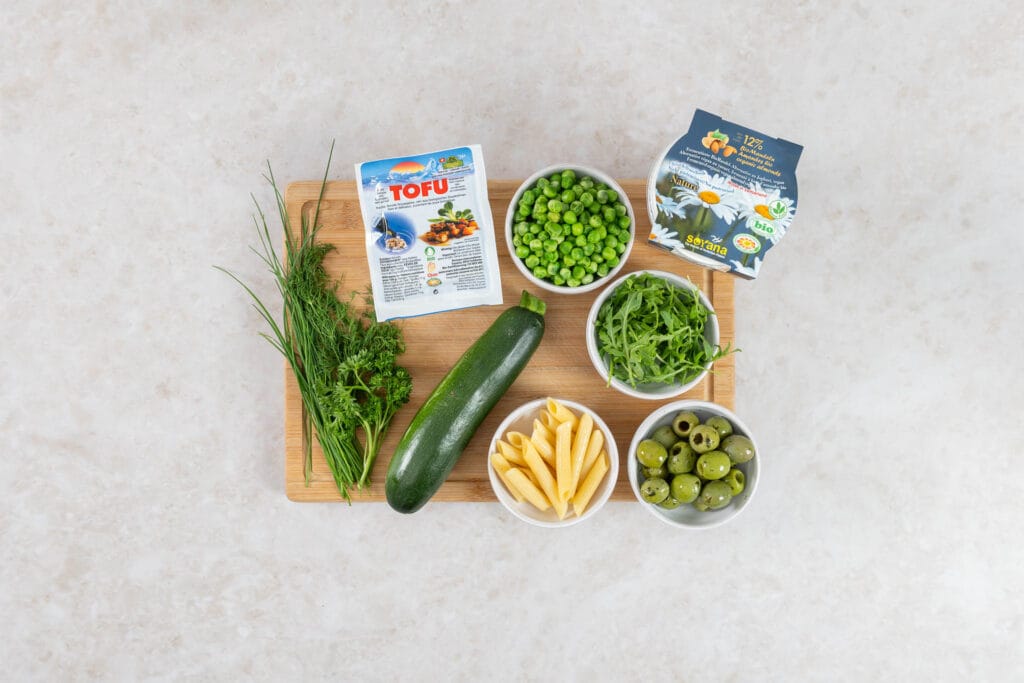 Zutaten für veganen Green Goddess Pastasalat mit Penne, Erbsen, Zucchetti, Oliven, Rucola und Soyana Bio-Tofu