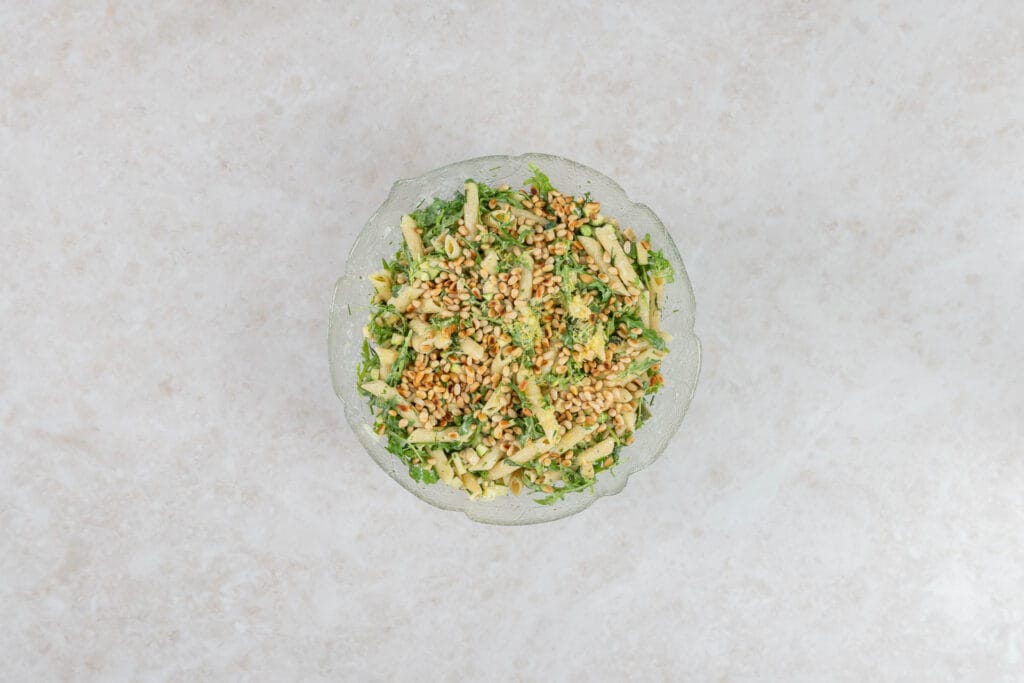 Veganer Green Goddess Pastasalat mit gerösteten Pinienkernen und Zitronenabrieb bestreut