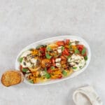Grillierter Aprikosensalat mit veganer Ricottacreme, serviert mit einer Scheibe knusprigem Knoblauchbrot