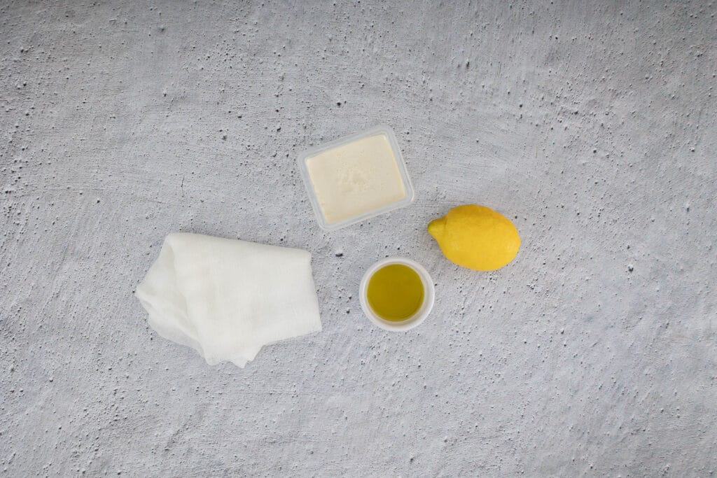 Zutaten für veganen Ricotta aus drei Zutaten: Seidentofu, Zitrone, Olivenöl und Mulltuch
