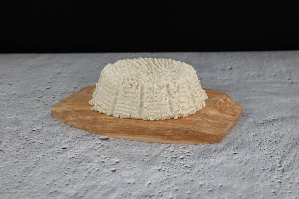 Veganen Ricotta selber machen, fest geformt auf einem Holzbrett