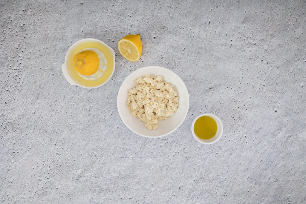 Abgetropfter, zerbröselter Seidentofu mit Zitronensaft und Olivenöl