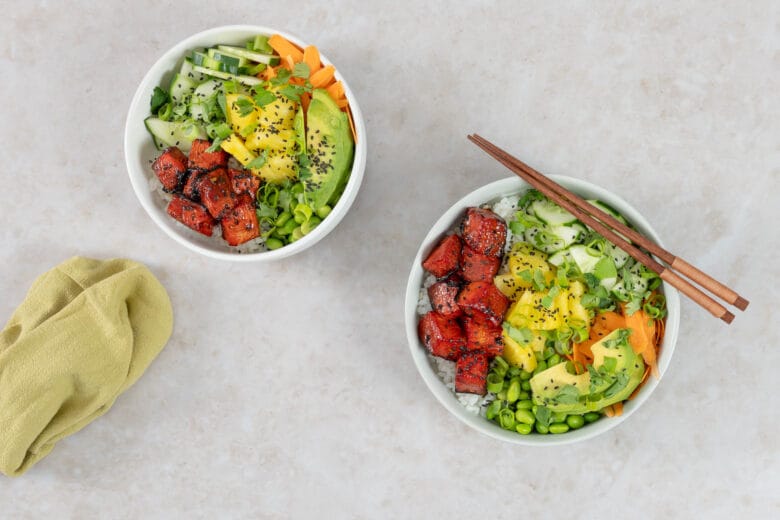 Zwei vegane Poké Bowls mit Wassermelonen-Thunfisch, Avocado, Ananas und Edamame auf Sushi-Reis angerichtet