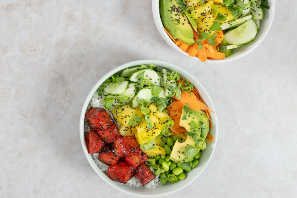 Vegane Wassermelonen-Thunfisch Poké Bowl aus der Nähe mit gebackener Melone, Ananas, Avocado und Sesam