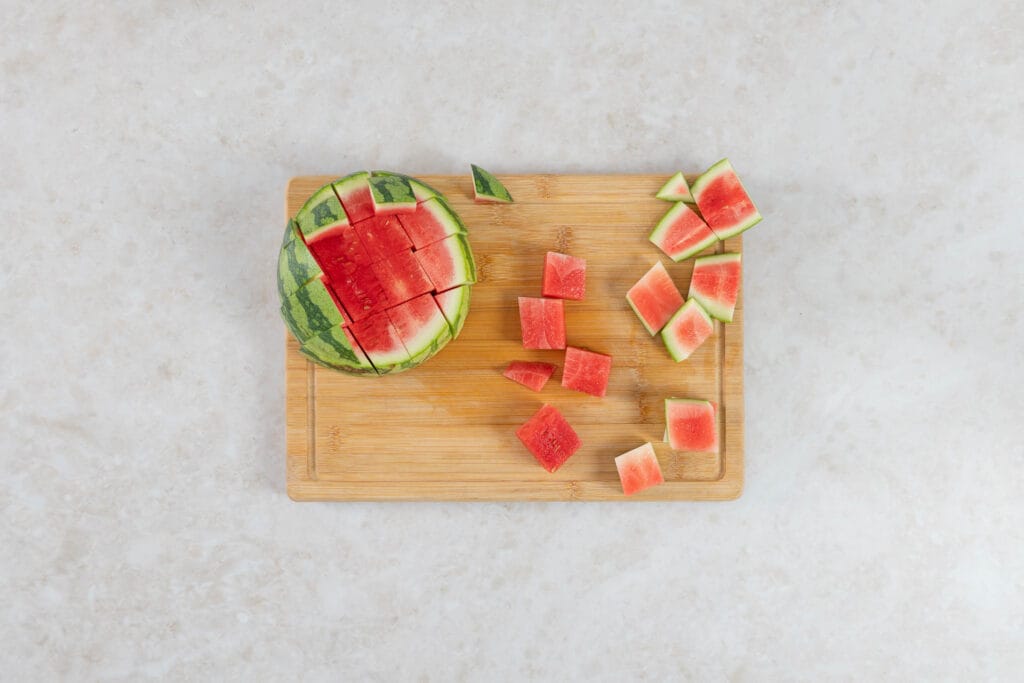 Wassermelone für veganen Thunfisch in etwa 3 cm grosse Würfel geschnitten auf einem Holzbrett