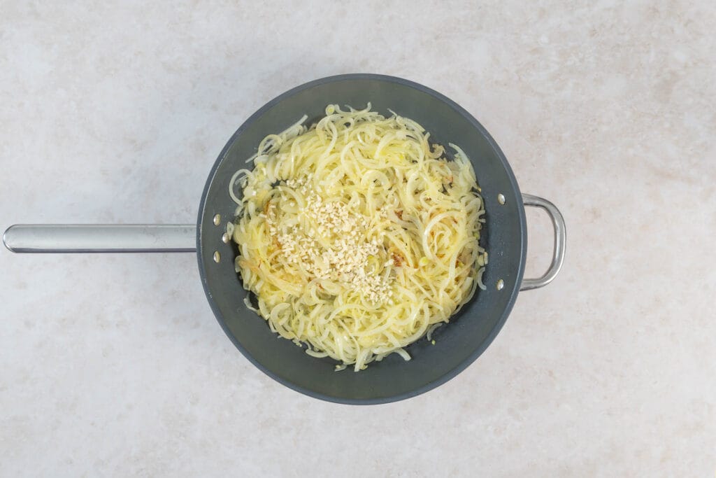 Goldgelb gedünstete Zwiebeln mit gehacktem Knoblauch in der Pfanne nach rund 20 Minuten