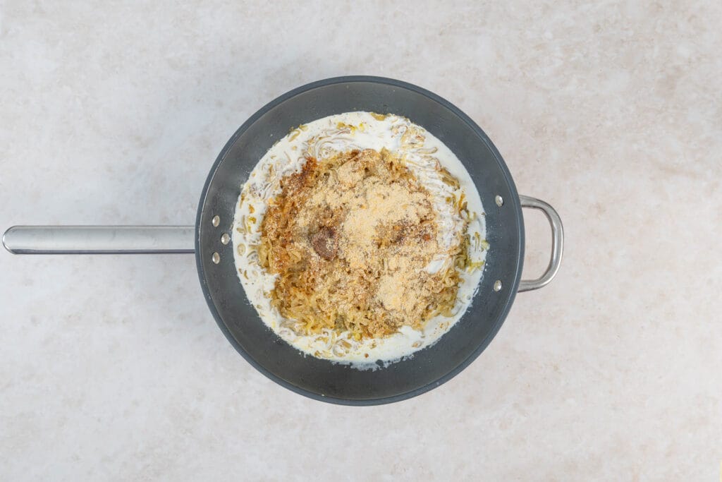 Rahm, Hefeflocken und Paprikapulver für die karamellisierte Zwiebel-Pasta in der Bratpfanne