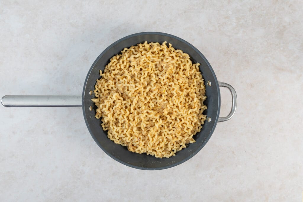 Pasta mit der karamellisierten Zwiebelsauce vermengt, bis sie gleichmässig überzogen ist