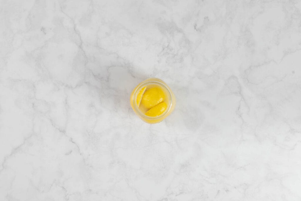 Zitronenviertel im Glas, mit Zitronensaft bedeckt, damit sie nicht schimmeln