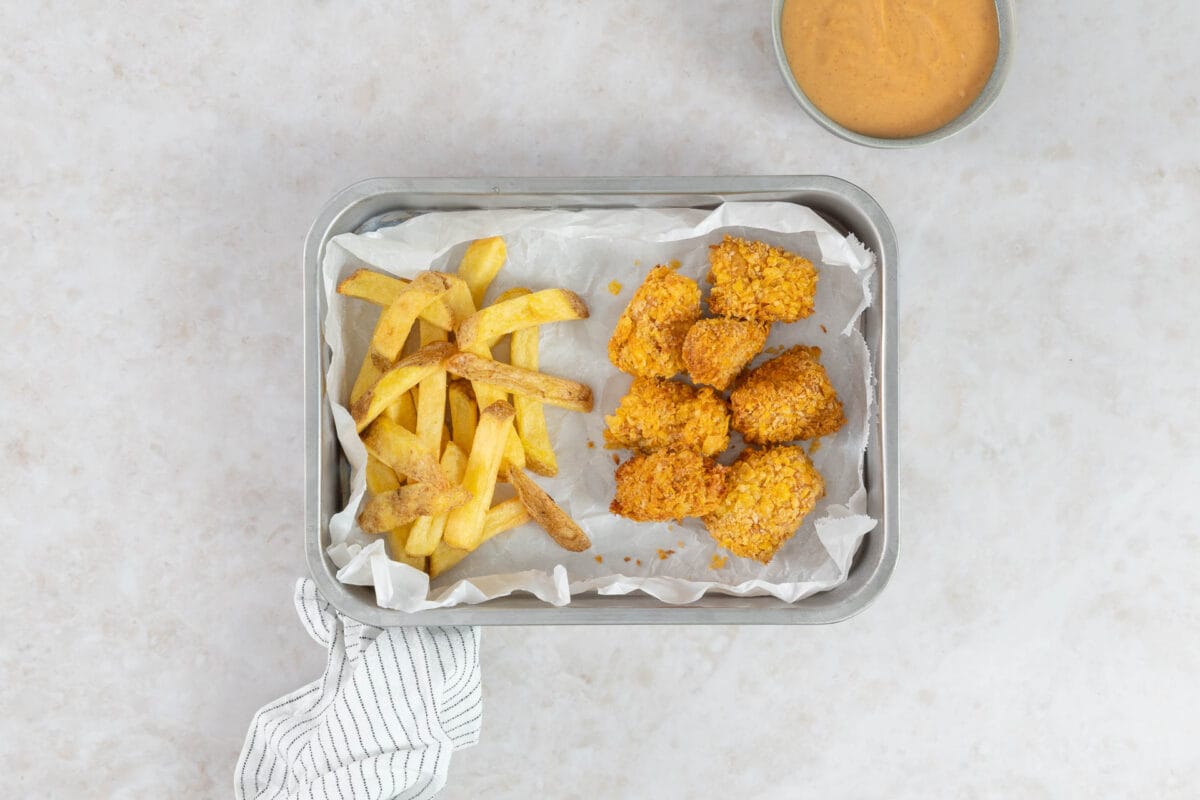 Goldbraune vegane Tofu Nuggets aus dem Airfryer mit Cornflakes-Panade, Pommes und Dip von oben