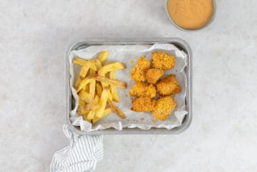 Goldbraune vegane Tofu Nuggets aus dem Airfryer mit Cornflakes-Panade, Pommes und Dip von oben