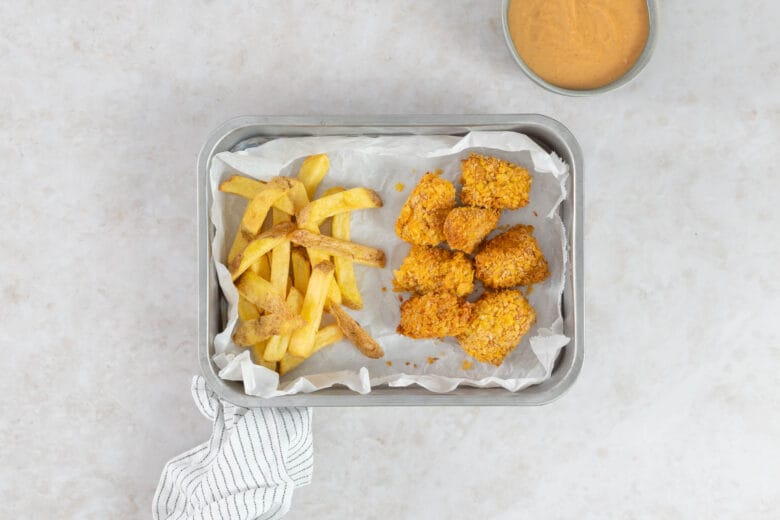 Goldbraune vegane Tofu Nuggets aus dem Airfryer mit Cornflakes-Panade, Pommes und Dip von oben