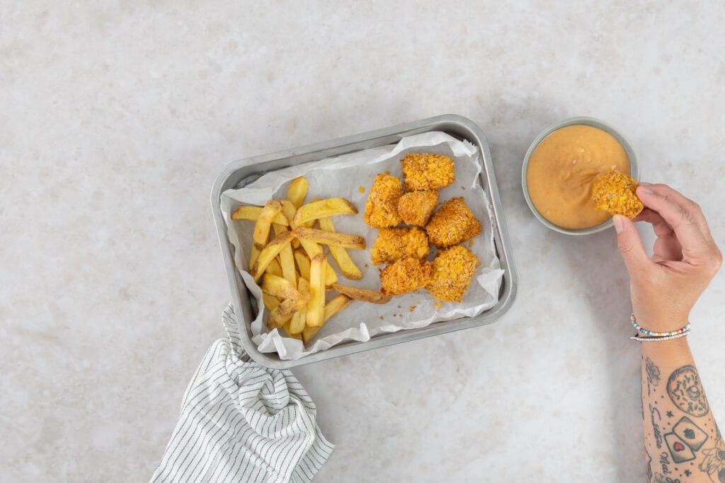 Hand tunkt eine knusprige Tofu Nugget in die Chick-fil-A-Sauce